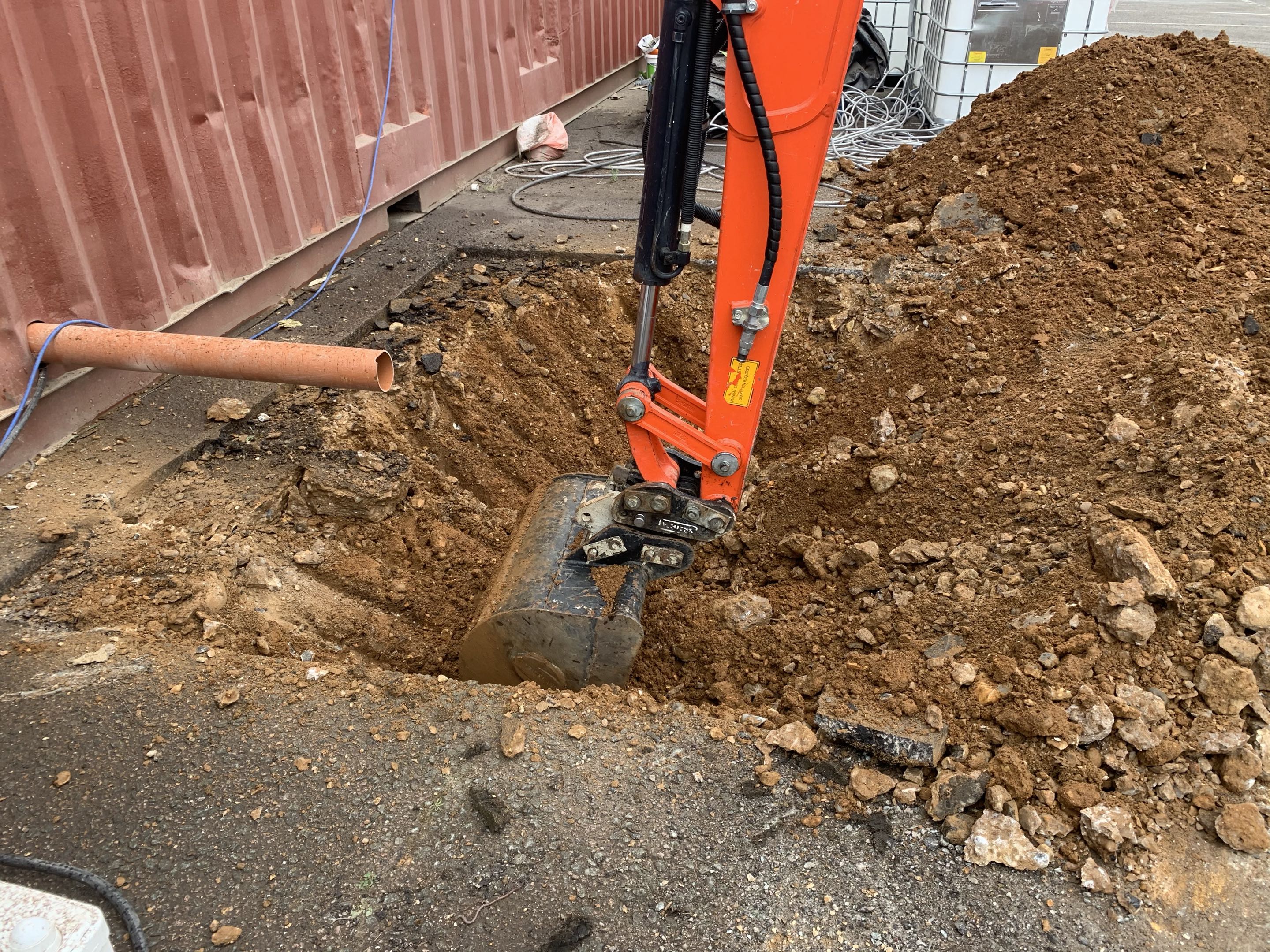 Excavator bucket shaping trench base